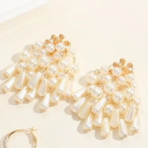 Gros plan de boucles d'oreilles vintage dorées avec perles et glands en forme de goutte
