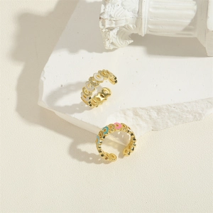 Colorful enamel and zircon open rings with wavy interlocking design on stone
