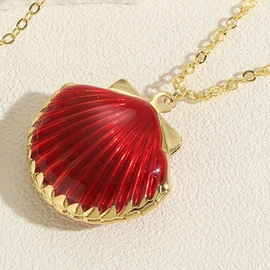 Macro shot of a red shell pendant with golden metallic texture and an O-style chain