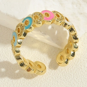 Detail of gold open ring with colorful enamel inlay and sparkling zircon stones