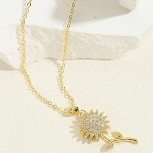 Detailweergave van de draaibare zonnebloem hanger met zirkonia op witte steen