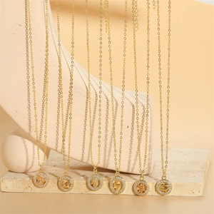 Gold round pendant necklaces with zodiac crab and lightning charms set with zircons
