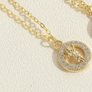 Detailed macro view of gold-plated cupid necklace featuring a sparkling zircon circle