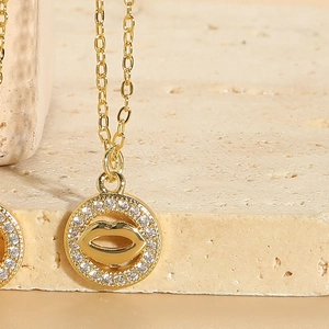 Macro detail of gold lip pendant with sparkling cubic zirconia on a stone surface