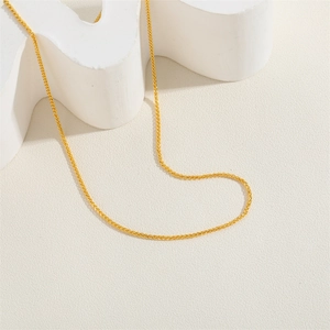 Detailed view of the delicate gold-plated wheat chain link texture on a white background
