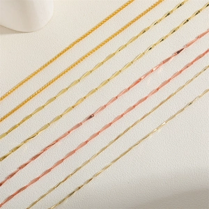 Golden and rose gold water wave and wheat chains displayed on a textured background