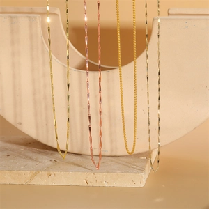 Water wave and curb chain necklaces in gold and rose gold finishes on stone base