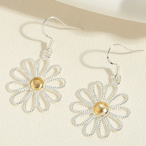 Vue détaillée de boucles d'oreilles marguerites tressées en fil d'argent et perle dorée