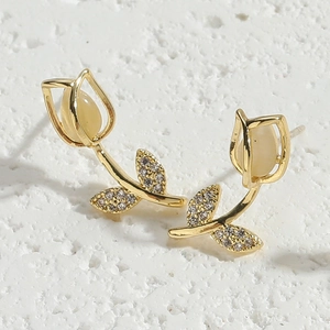 Close-up of golden tulip stud earrings with opal flower buds and small inlaid diamonds