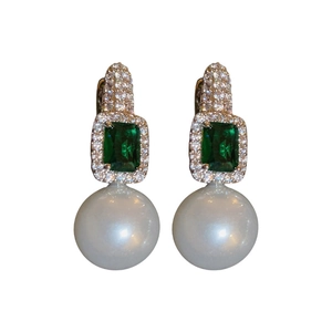Détail de boucles d'oreilles en bambou avec pierres vertes et perles pendantes