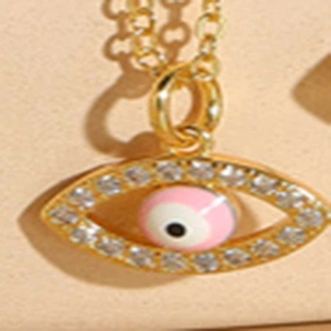 Dettaglio della collana con ciondolo malocchio dorato con smalto rosa e cristalli
