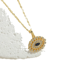 Goldene Evil Eye Halskette mit blauem Stein und weißen Zirkonia auf weißem Steinständer