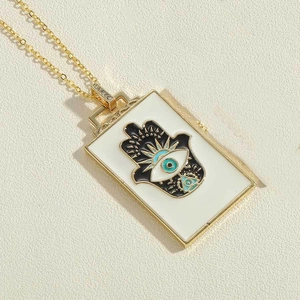 Detailansicht eines goldenen Hamsa-Hand-Anhängers mit bösem Blick an feiner Kette