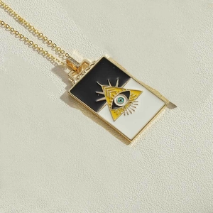Makroaufnahme des rechteckigen Evil Eye Anhängers mit Emaille-Dreieck und Goldhalskette