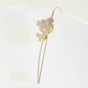 Detailed view of long gold ear cuff featuring sparkling crystal butterfly and leaf motifs