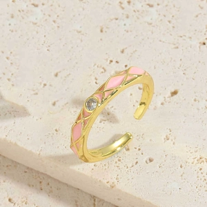 Detail van verstelbare gouden ring met roze ruitvormige emaille en centrale zirkoon