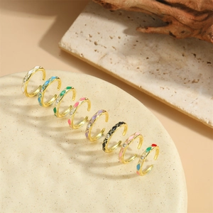 Franse vintage emaille ringen met zirkonen in gouden zetting op stenen achtergrond