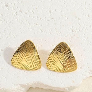 Detailed macro view of 14K gold plated triangle stud earrings with brushed texture