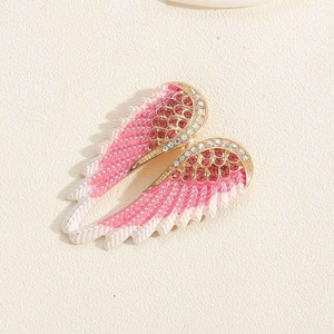 Detail van engelenvleugel speldjes met roze veren en schitterende strass-steentjes