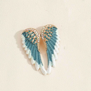 Detail van engelenvleugel broche met kristallen, groenblauwe veren en gouden afwerking