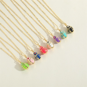Detail of colorful oval enamel pendants with golden floral patterns on O-chains