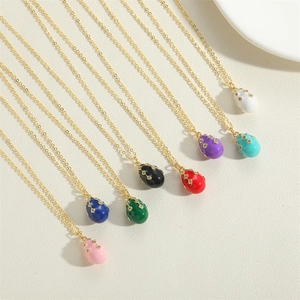 Detailed macro view of eight colorful enamel teardrop pendants on gold necklaces
