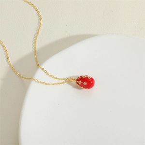 Elegant gold O-chain necklace featuring a red egg-shaped pendant with sparkling crystals