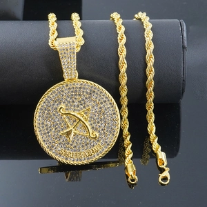 Dettaglio del ciondolo Sagittario dorato con strass bianchi su una catena a corda spessa