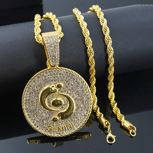 Dettaglio del ciondolo Gemini con cristalli scintillanti su una collana a catena dorata