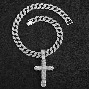 Detail of hip-hop iced out Cuban chain with a large cross pendant on black leather