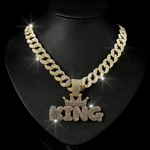 Close-up of hip hop gold Cuban link chain with a sparkling diamond encrusted KING crown pendant