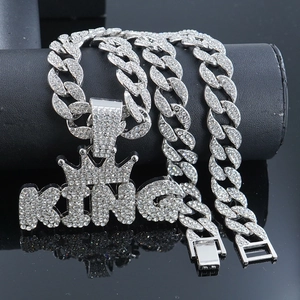 Close-up of silver iced out KING pendant with crown on heavy Cuban link chain