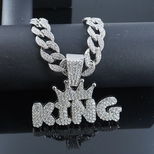 Macro shot of silver hip hop KING crown pendant with shimmering crystals on Cuban chain