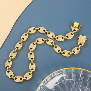Macro shot of gold coffee bean link chain with pavé crystals and folding clasp