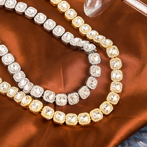 Détail de colliers hip hop or et argent avec zircons carrés sur un fond en soie douce