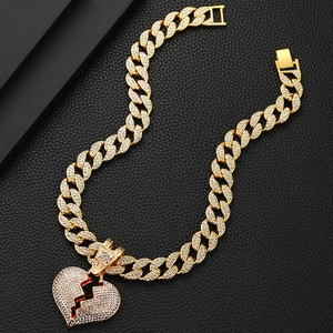 Dettaglio della collana dorata con ciondolo a cuore spezzato e pavé di zirconi bianchi