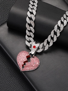 Detail of pink and white diamond encrusted broken heart pendant on silver Cuban chain