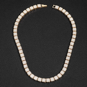 Détail du collier tennis doré avec cristaux carrés pavés sur une surface en cuir noir