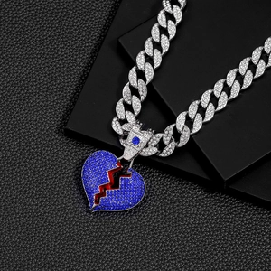 Close-up of hip hop cuban chain featuring a large broken heart pendant with blue crystals