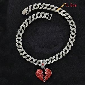 Detail showing 1.5cm wide iced out Cuban chain with red broken heart pendant