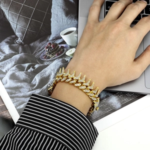 Dettaglio del bracciale hip-hop a spine placcato in oro con strass scintillanti incastonati