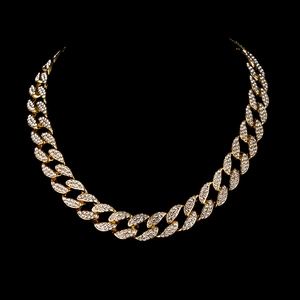 Gros plan détaillé du collier à maillons cubains dorés avec strass micro-pave glacés