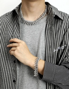 Dettaglio del set collana e bracciale hip-hop a spine con cristalli e finitura argento