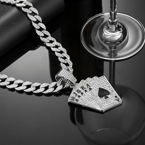 Chaîne cubaine glacée avec pendentif cartes de poker scintillant sur surface noire