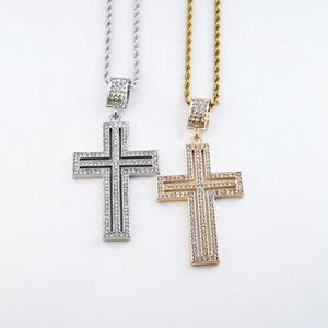 Macro detail of iced out gold and silver cross pendants with shimmering white crystals