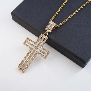 Macro detail of gold-tone iced out cross pendant with sparkling white zircons