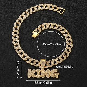 Detailed macro view of iced-out KING letter pendant on golden Cuban link hip-hop chain