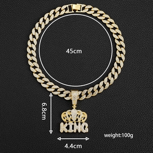 Detail view of gold Cuban chain with iced-out KING crown pendant and size specs