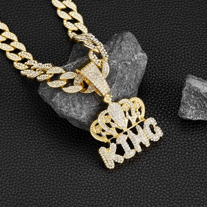 Macro shot of gold hip hop King crown pendant with rhinestones on Cuban link chain