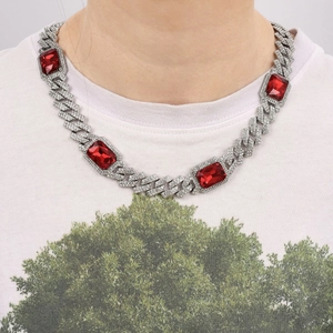 Detail of silver Cuban link necklace with ruby red rectangle stones and pave diamonds